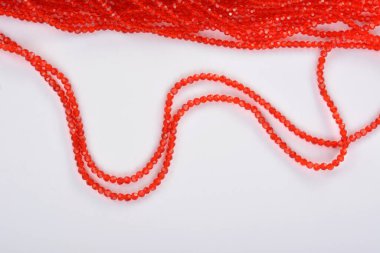 Güzel kırmızı kırmızı, beyaz arka planda yakut rengi cam parıltılı kristal boncuklar. Boncuklu mücevherler için kullan. Metin için boşluk