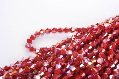 Güzel kırmızı kırmızı, beyaz arka planda yakut rengi cam parıltılı kristal boncuklar. Boncuklu mücevherler için kullan. Metin için boşluk