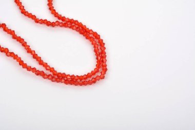 Güzel kırmızı kırmızı, beyaz arka planda yakut rengi cam parıltılı kristal boncuklar. Boncuklu mücevherler için kullan. Metin için boşluk