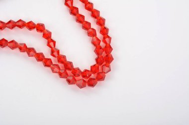 Güzel kırmızı kırmızı, beyaz arka planda yakut rengi cam parıltılı kristal boncuklar. Boncuklu mücevherler için kullan. Metin için boşluk