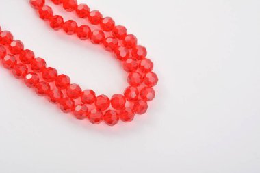 Güzel kırmızı kırmızı, beyaz arka planda yakut rengi cam parıltılı kristal boncuklar. Boncuklu mücevherler için kullan. Metin için boşluk