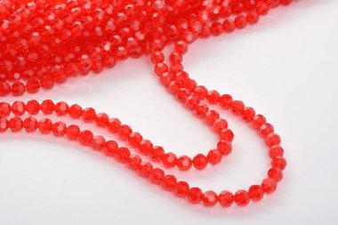 Güzel kırmızı kırmızı, beyaz arka planda yakut rengi cam parıltılı kristal boncuklar. Boncuklu mücevherler için kullan. Metin için boşluk