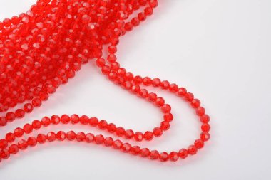 Güzel kırmızı kırmızı, beyaz arka planda yakut rengi cam parıltılı kristal boncuklar. Boncuklu mücevherler için kullan. Metin için boşluk