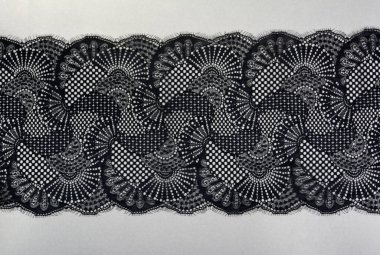 Gri arka planda siyah gri renkli dantel kumaş şeridi. Elastik ipek naylon örgü kenarı. Çamaşır bezi dekorasyonunu kullan. Tekrarlanan desenler ve birbirine dolanan iplikler. Web siteleri için doku