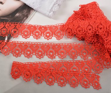 Kırmızı yumuşak iplik bantları, güzellik dantelli kumaş. Elastik malzeme. Atıcı ve nakış dükkanı için kullanılıyor. Mesaj için yer var. Tekrarlanan desenler ve birbirine dolanan iplikler. Web siteleri için doku