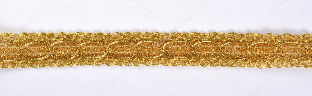 Braid lace made Luxury Metallic golden cord on white background. decoration for carnival and dance clothes costumes. Christmas texture. banner for website