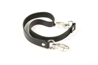 Siyah deri kemer ve beyaz arka planda metal aksesuarlar. Çantalar ve bavullar için kullan