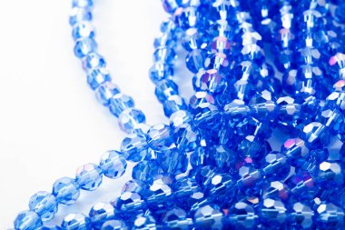 Beyaz arka planda güzel mavi cam kristal boncuklar. Boncuklu mücevherler için kullan. Metin için boşluk