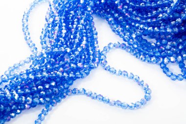 Beyaz arka planda güzel mavi cam kristal boncuklar. Boncuklu mücevherler için kullan. Metin için boşluk