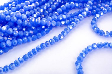 Beyaz arka planda güzel mavi cam kristal boncuklar. Boncuklu mücevherler için kullan. Metin için boşluk