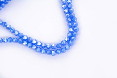 Beyaz arka planda güzel mavi cam kristal boncuklar. Boncuklu mücevherler için kullan. Metin için boşluk