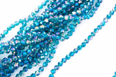 Beyaz arka planda zümrüt mavisi parlak kristal boncuklar. Boncuklu mücevherler için kullan. Metin için boşluk