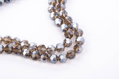 Güzel bej rengi kahverengi cam parıltılı kristal boncuklar beyaz arka planda. Boncuklu mücevherler için kullan. Metin için boşluk