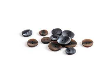 Yığınla, her çeşit kahverengi gri, bej ve kahverengi düğmeler beyaz arka planda. Dikiş ve terzi dükkanı için görüntü. Metin için boşluk