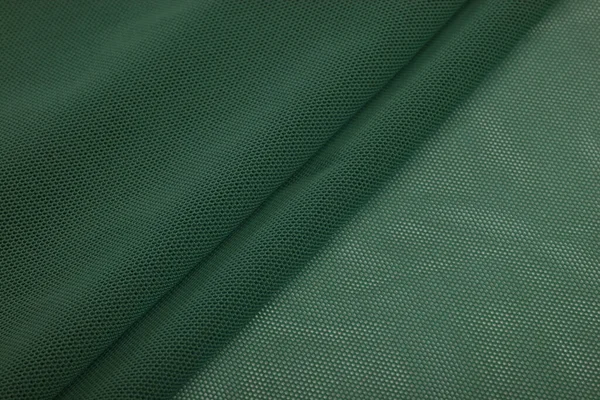 緑のニット弾性生地 糸のテクスチャの織り 折り目の折り目 スポーツ服や水着のために テキストのスペース — ストック写真