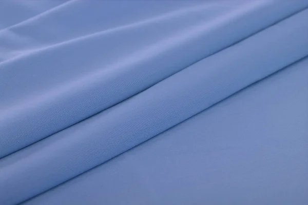 青いニット弾性生地 糸の質感の織り 折り目の折り目 スポーツ服や水着のために テキストのスペース — ストック写真