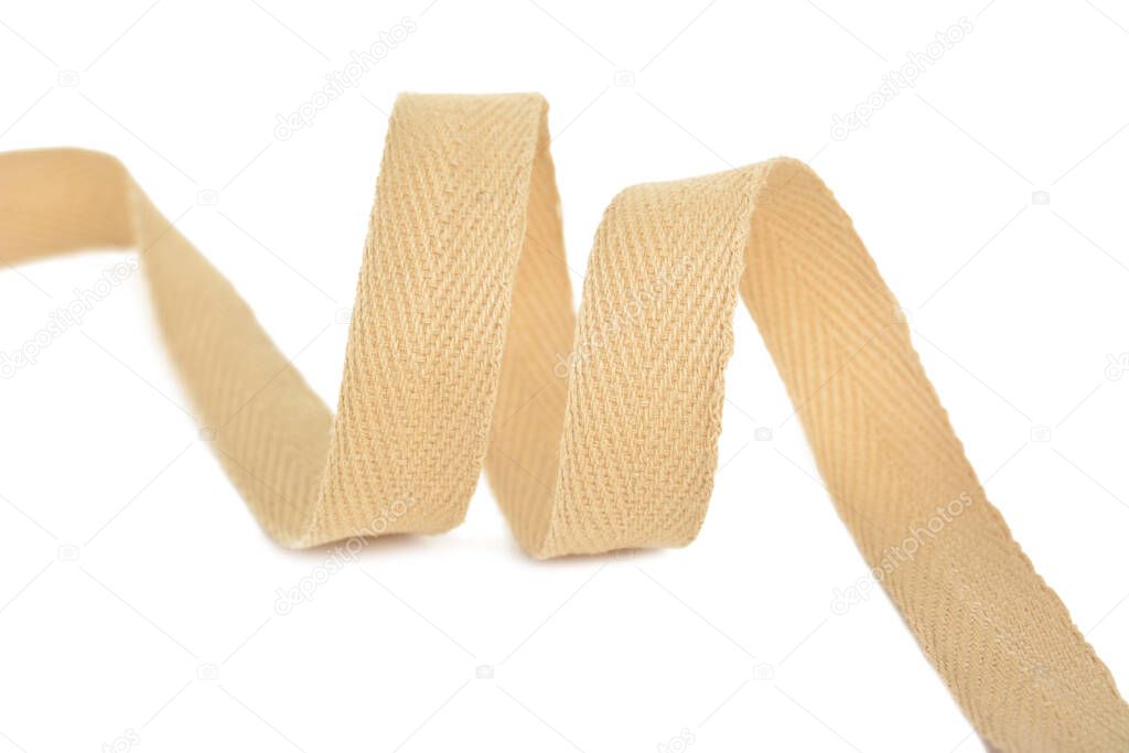 beige Twisted ribbon of cotton Keeper braid on white background. Tape For sewing clothes.