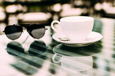 Bir bardak aromatik kahve, telefon ve defter ile bir masada oturan bir adamın eli. İş yemeği