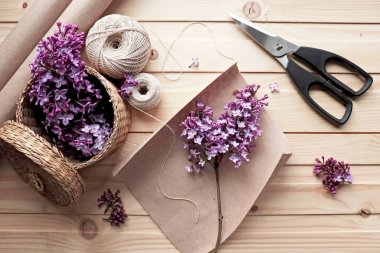 Bir buket leylağın yaratılması. Bahar çiçekleri. Kağıt üzerinde bir tutam leylak. İplik, makas, kağıt. Tahta masa. El yapımı iş. Hobi.