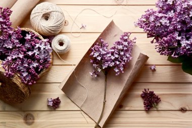 Bir buket leylağın yaratılması. Bahar çiçekleri. Kağıt üzerinde bir tutam leylak. İplik, makas, kağıt. Tahta masa. El yapımı iş. Hobi.