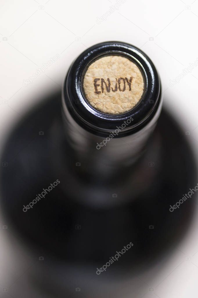 Top close view of unopened dark glass bottle of red wine with cork with 