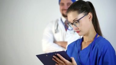 Yetişkin doktor kameraya bakar ve notlar alır. Dikkatle dinler ve hastaya tedavi önerir. İzole arka plan. Yakın çekim