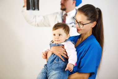 Bir doktor, Doktor arka planda kollarında mutlu çocuk röntgen görünüyor. Beyaz arka plan