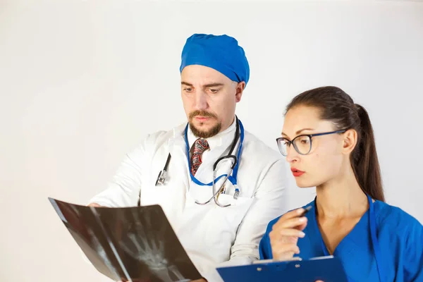 Dos médicos analizan el resultado de una radiografía, hay un problema y discuten el tratamiento. Fondo blanco — Foto de Stock