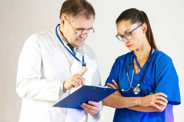 Kıdemli doktor genç kadın doktora tedavi reçete açıklar