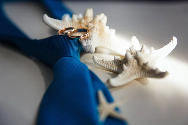 Anillos de boda están esperando la celebración, corbata y estrellas de mar —  Fotos de Stock