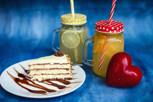 Bir dilim pasta güzel servis. Kavanoz ve kırmızı bir kalp içinde arka plan limonata