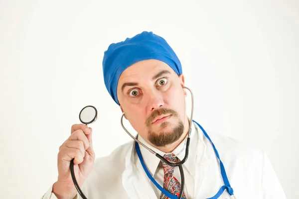 İri gözlü çılgın doktor stetoskop bir tutar ve kameraya doğru görünüyor