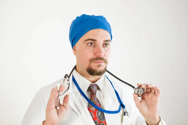 Genç bir doktor stetoskop bir elinde tutar ve onun önünde görünüyor