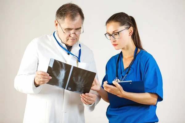 Dos doctores miran una radiografía de la mano y discuten el problema — Foto de Stock