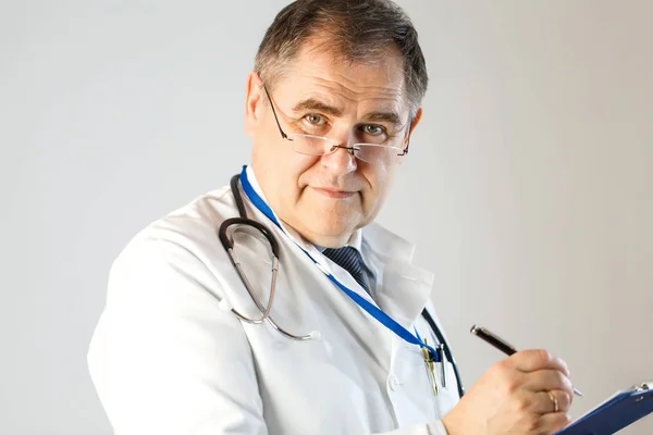 Doktor reçete yazıyor ve yüzüne bakar