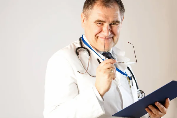 Gözlük ve kayıtları için bir klasör tutan doktor ilaç gülümsüyor,