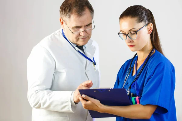 Doktor se dívá na výsledky pacientovy záznamy na kartě, v nemocnici — Stock fotografie