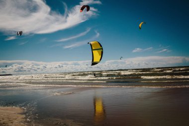 Kitesurfing Baltık Denizi kıyısında. Parlak güneş ve iyi bir hava. Aktif spor