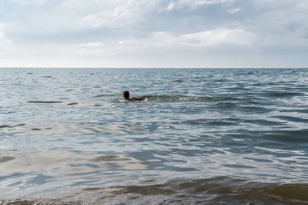 Adam baykal soğuk gölde yüzüyor