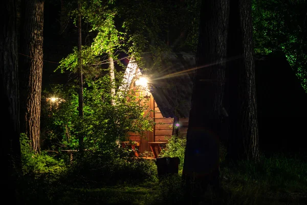 wooden house in the forest in the light of a lantern