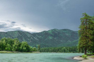 turkuaz nehir ve dağlar ve gök gürültülü bulutlar