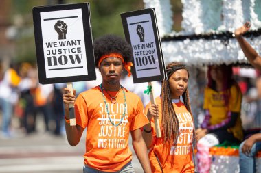 Chicago, Illinois, ABD - 8 Ağustos 2019: The Bud Billiken Parade, Sosyal Adalet ve Özgürlüğü destekleyen pankartlar tutan kadın ve erkek