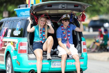 Arlington, Teksas, ABD - 4 Temmuz 2019: Arlington 4 Temmuz Geçit Töreni, bir minibüse binen kadın ve adam, Epic Waters 'ın kapalı su parkının tanıtımı