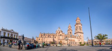 Morelia, Michoacan, Meksika - 24 Kasım 2019: Arka plandaki Morelia Katedrali ile Menchor Ocampo Plaza 'da sabahın tadını çıkaran insanlar