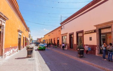 Dolores Hidalgo, Guanajuato, Meksika - 25 Kasım 2019: Guerrero Caddesi 'ndeki dükkanların önünden geçen ziyaretçiler ve yerliler