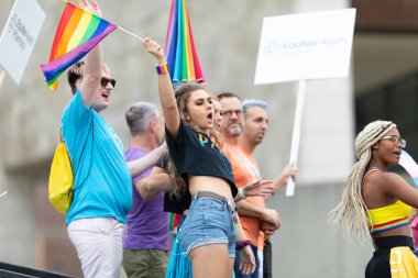 Cincinnati, Ohio, ABD - 22 Haziran 2019: Cincinnati Onur Yürüyüşü, geçit töreninde gökkuşağı bayraklarını sallayan insanlar