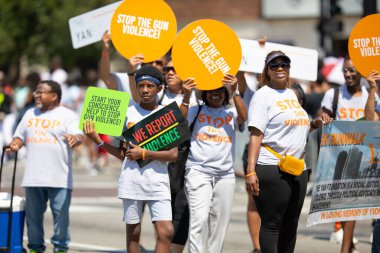 Chicago, Illinois, ABD - 8 Ağustos 2019 Bud Billiken Geçidi, geçit töreninde silahlı şiddeti protesto eden pankartlar tutan insanlar