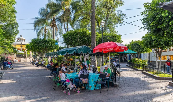 San Pedro Tlaquepaque, Jalisco, Meksika - 23 Kasım 2019: Hidalgo bahçesindeki turistler, yerel ve sokak satıcıları
