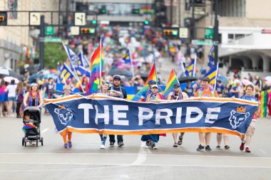 Cincinnati, Ohio, ABD - 22 Haziran 2019: Cincinnati Onur Yürüyüşü, gökkuşağı bayrakları sallayan ve FC Cincinnati 'yi tanıtan pankart taşıyan insanlar