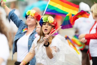 Cincinnati, Ohio, ABD - 22 Haziran 2019: Cincinnati Onur Yürüyüşü, geçit töreninde gökkuşağı bayrağı sallayan kadın
